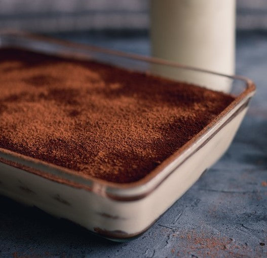 Sifted dutch cocoa falls to make a soft layer atop a homemade tiramisu